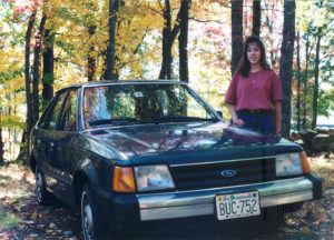 Andrea with her first car, a 1985 Ford Escort.